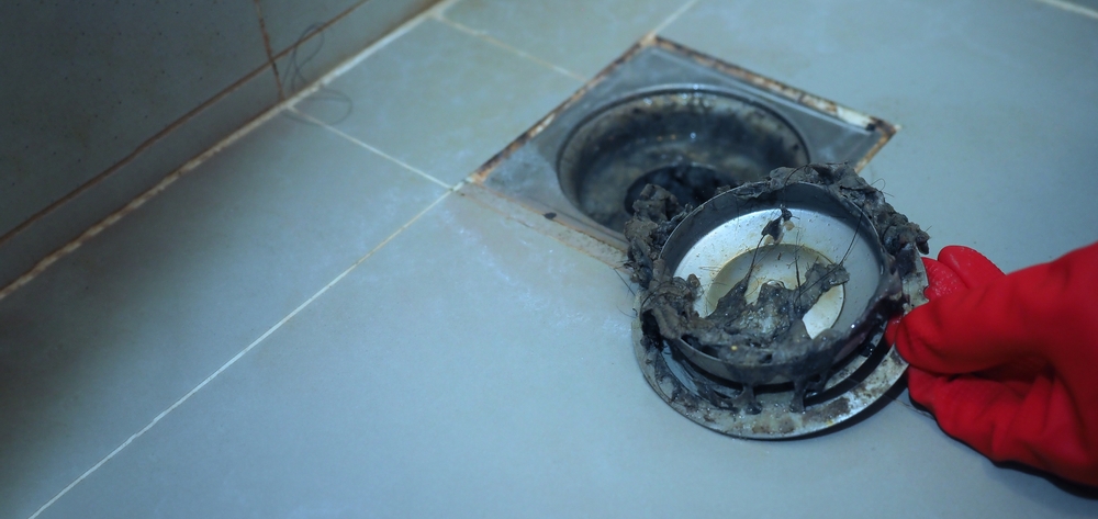 Plumber performing regular drain cleaning to prevent costly plumbing repairs